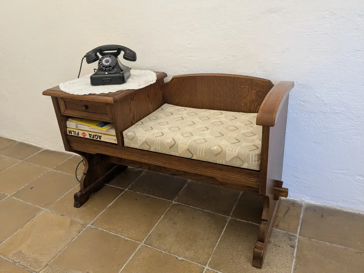 Sitzbank aus Holz, Telefon mit Wählscheibe